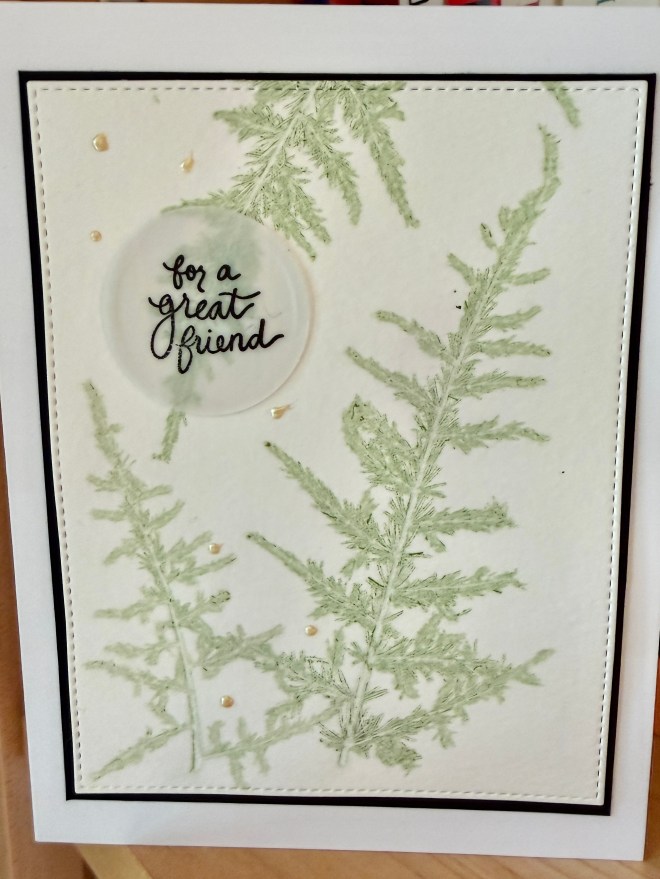 A greeting card featuring green fern leaves with the text 'for a great friend' in a circular cutout, embellished with small pearls.
